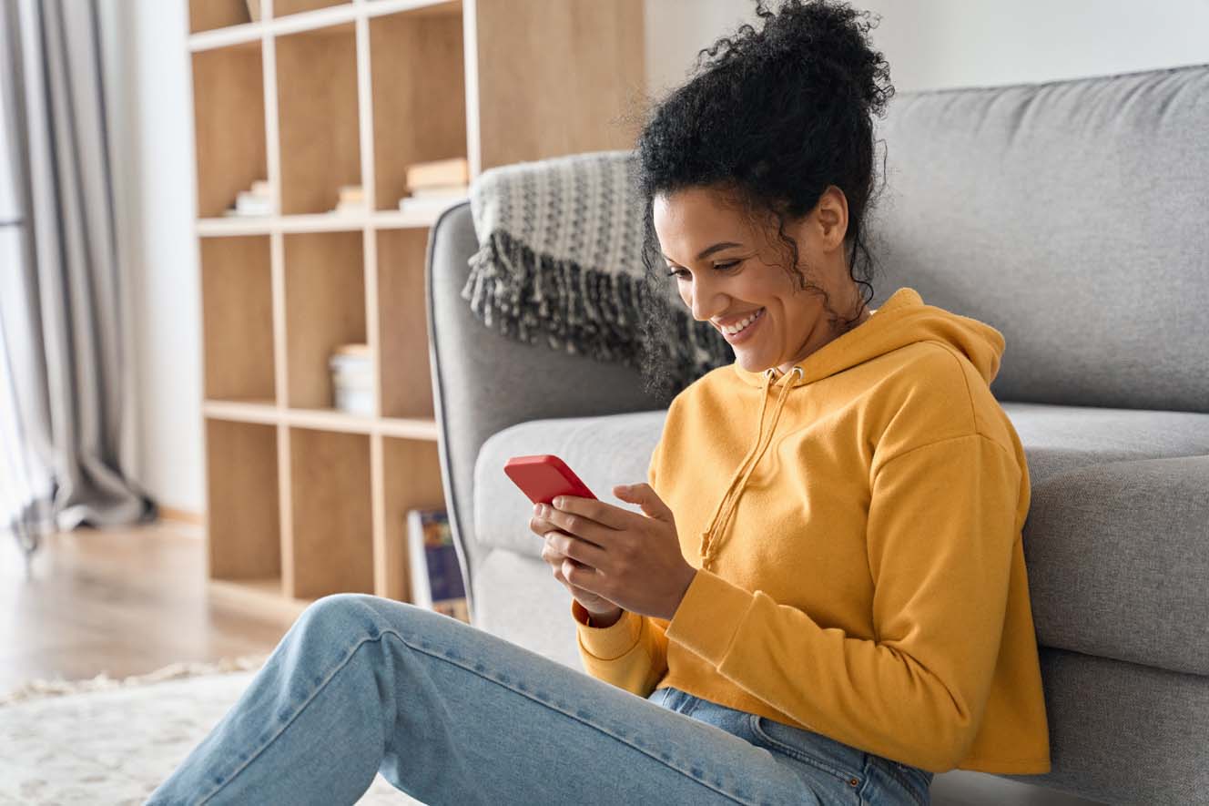 A young lady in her living room using her smartphone