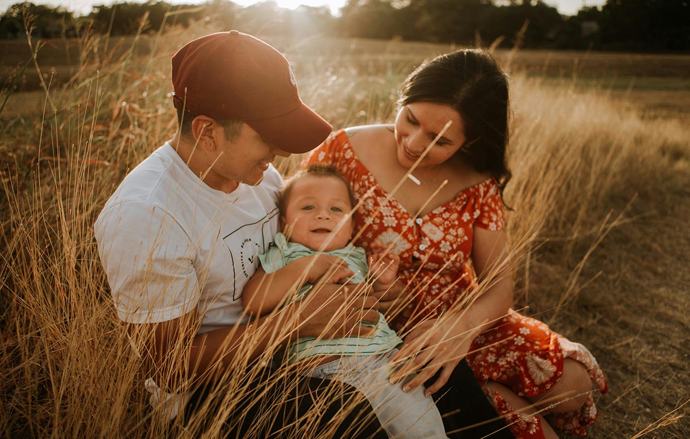 A young family sitting in a field